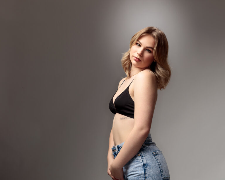 Woman in black top, posing confidently.
