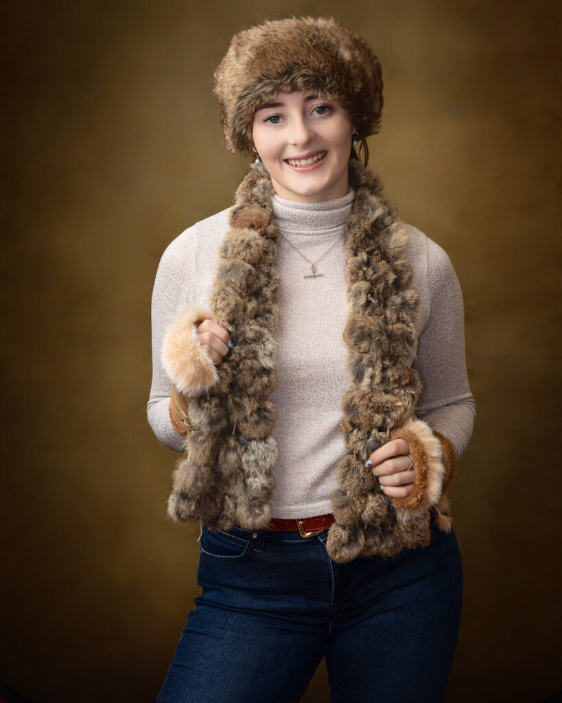 Person wearing cosy faux fur hat and scarf.