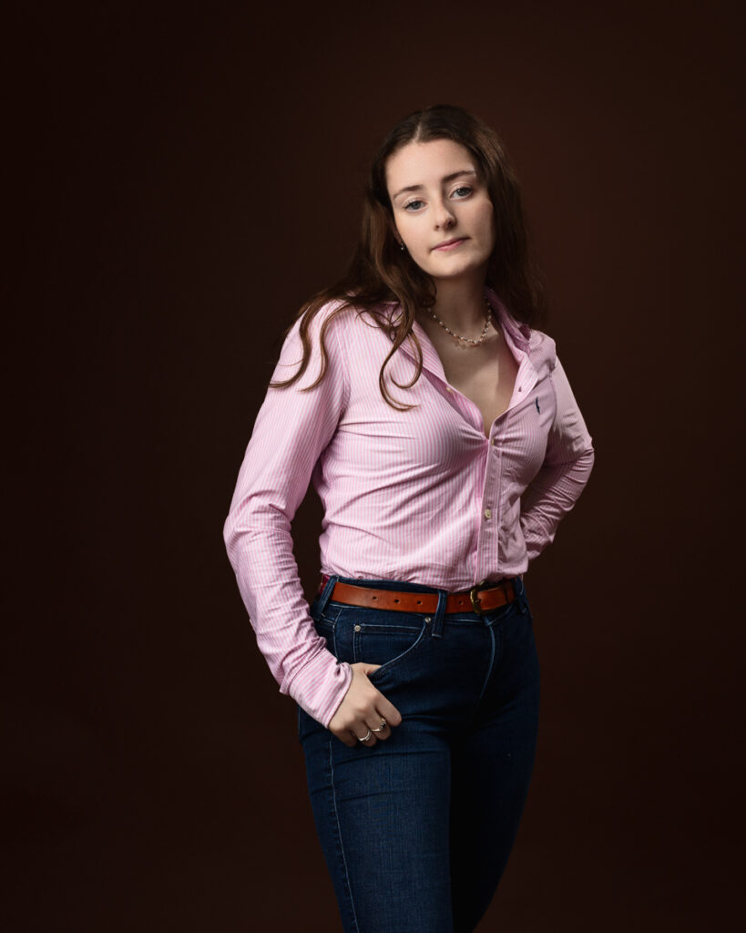 Woman in pink shirt and jeans posing.