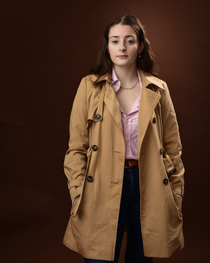 Woman in trench coat, brown background