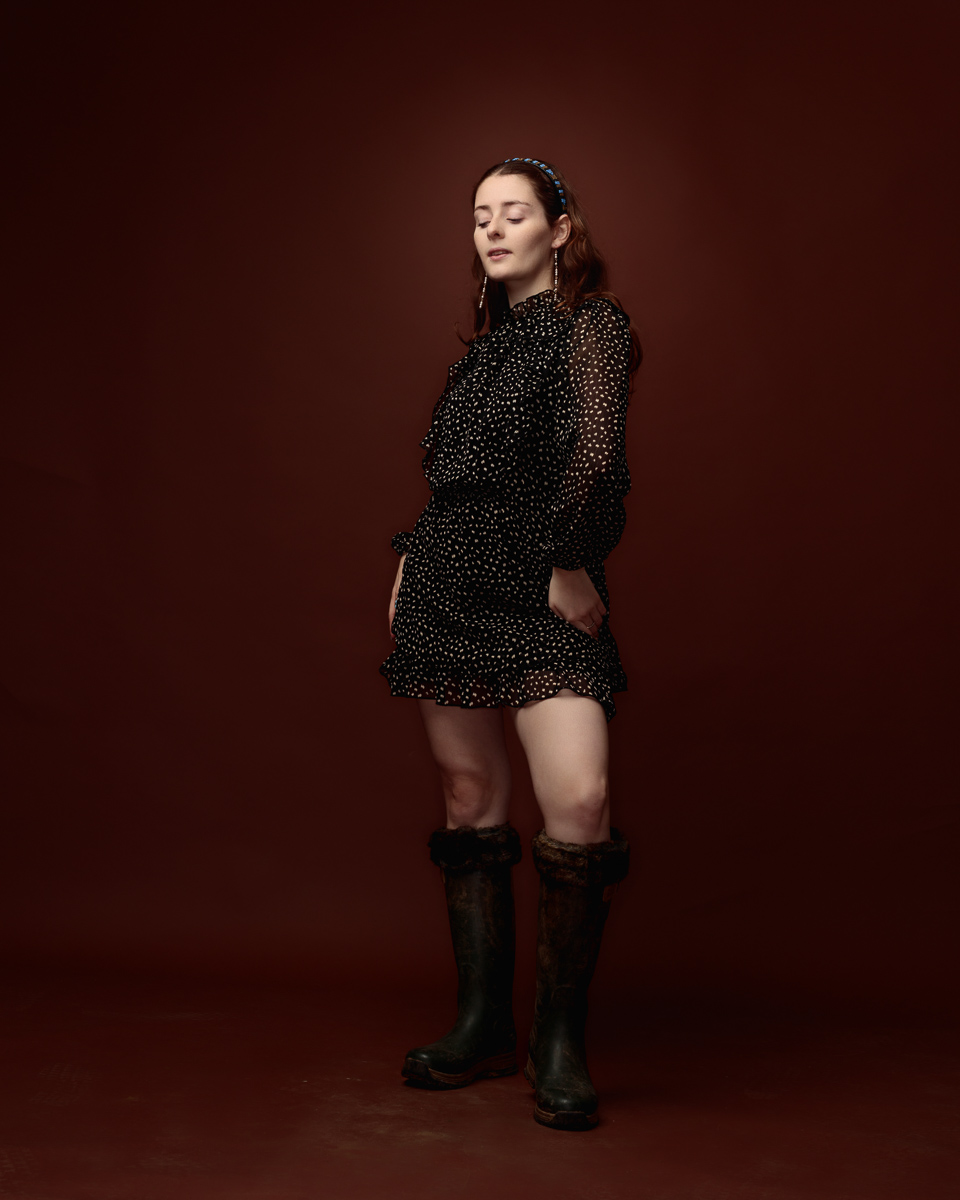 Woman in polka dot dress and boots posing
