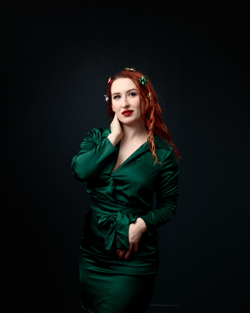 Woman in green dress with decorative hair accessories.