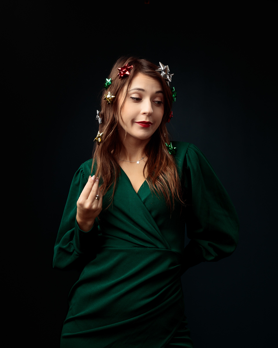 Woman in green dress with decorative bows.