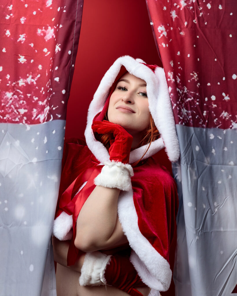 Person in Santa outfit between curtains