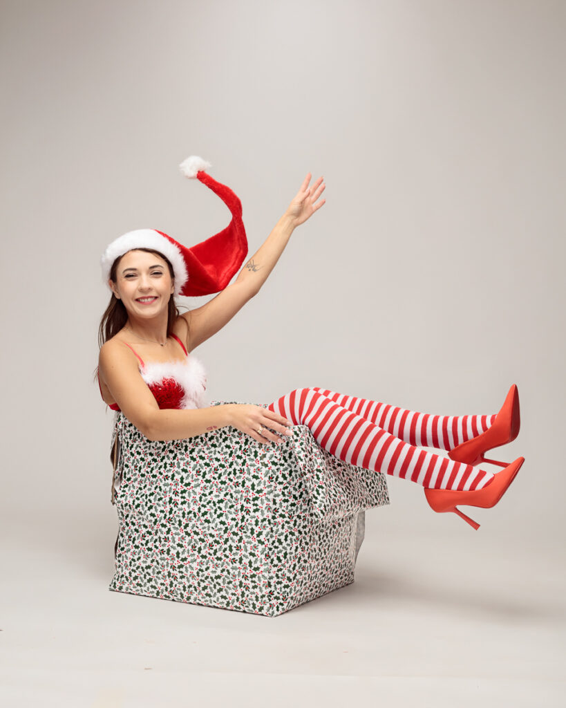Woman in festive outfit inside gift box
