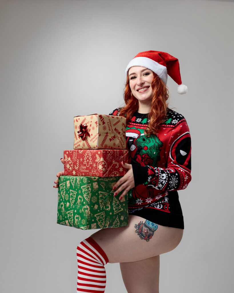 Smiling woman in festive attire holding gifts.