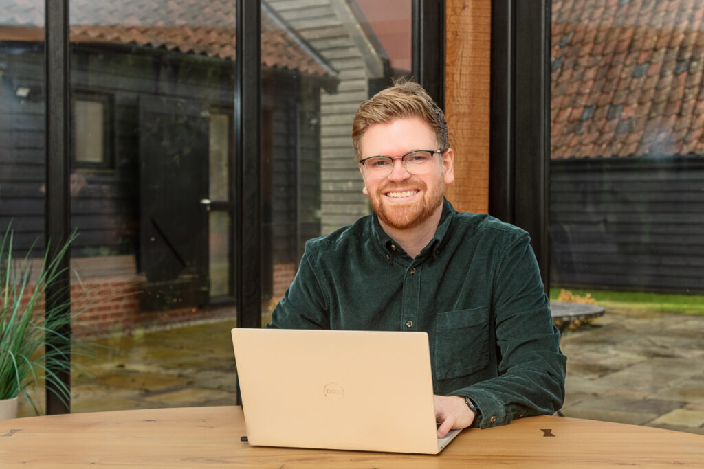 Man with laptop in conservatory workspace