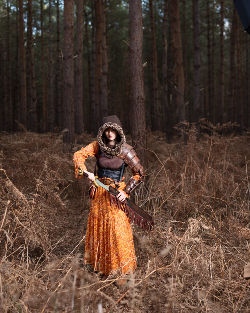 Woman in medieval armour in the forest.