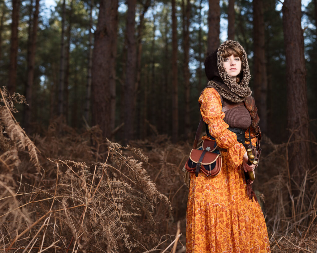 Person in vintage dress in forest, autumn background.