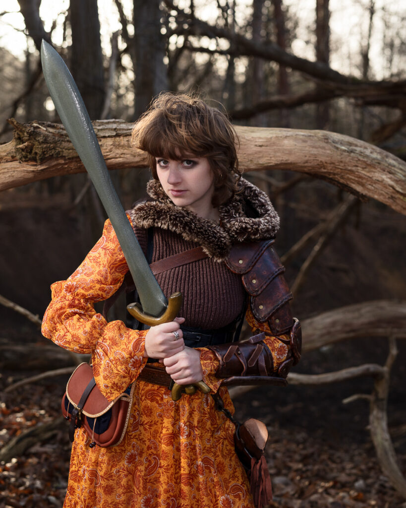 Medieval warrior with sword in autumn forest.