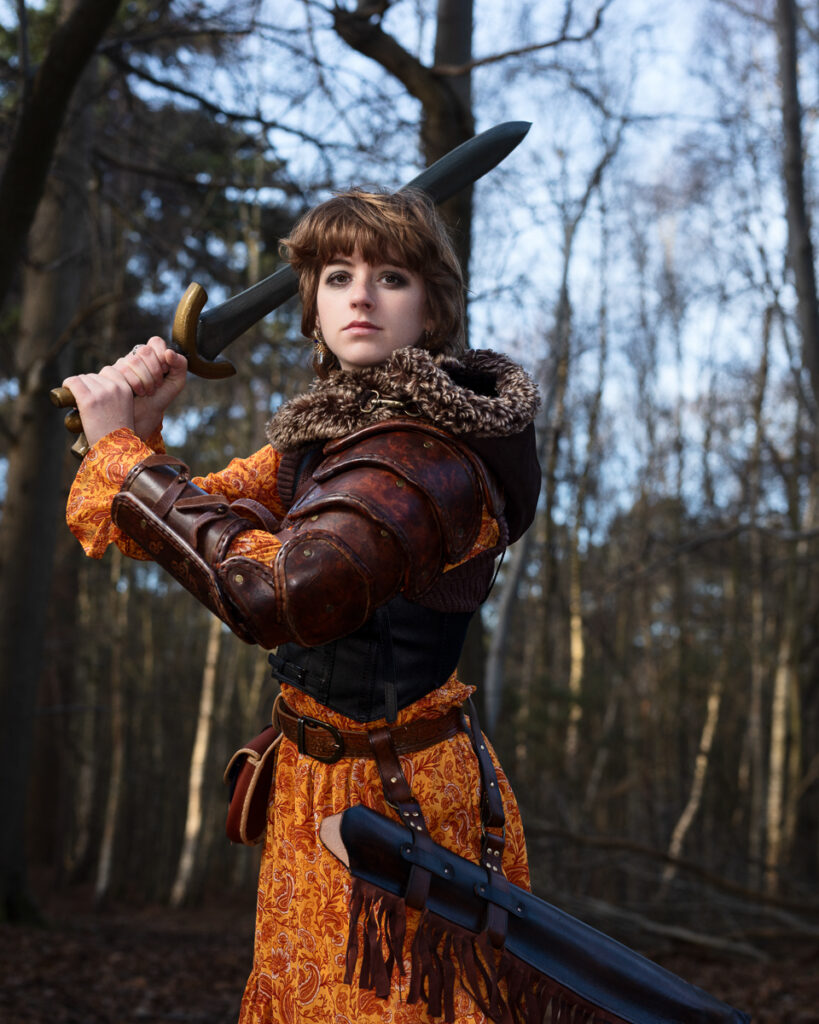 Medieval warrior woman with sword in forest