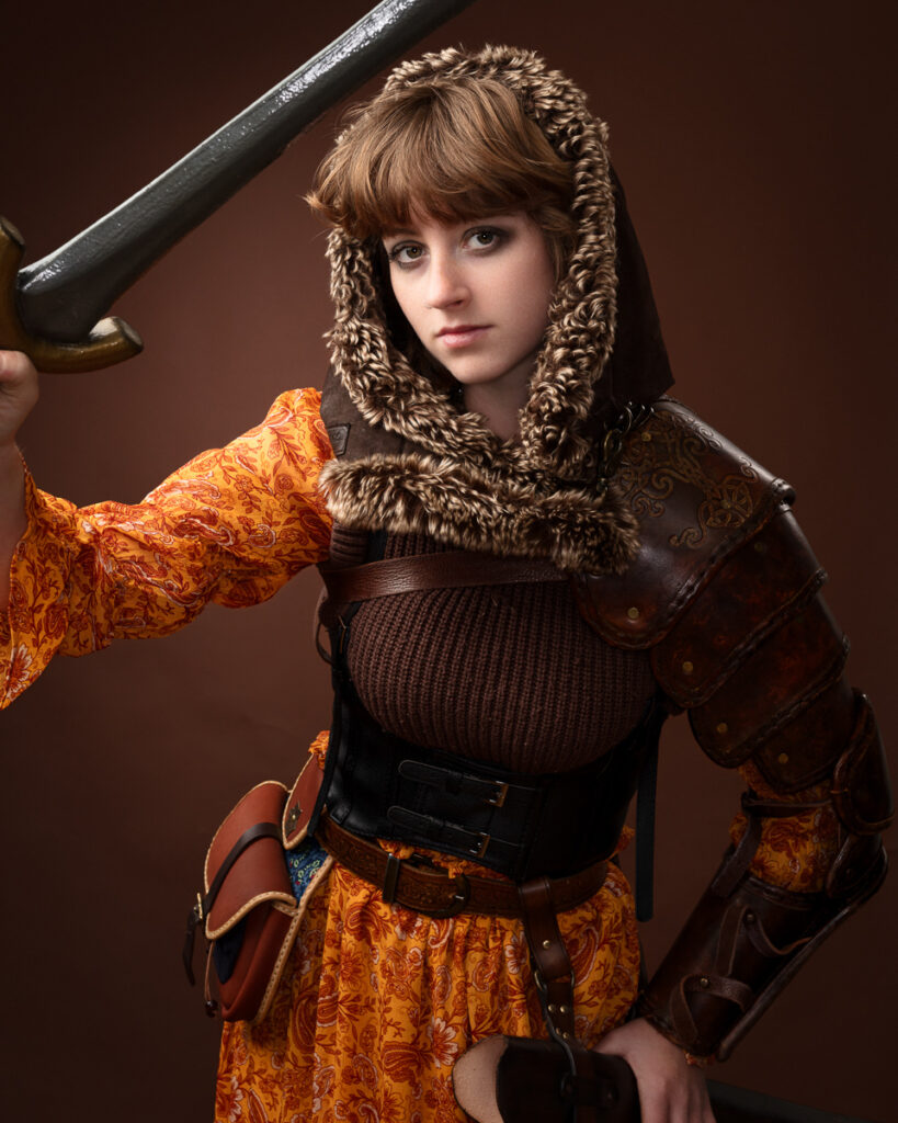 Woman in medieval armour holding a sword.
