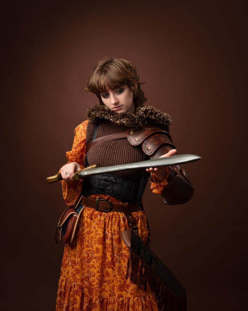 Woman in medieval costume holding a sword.