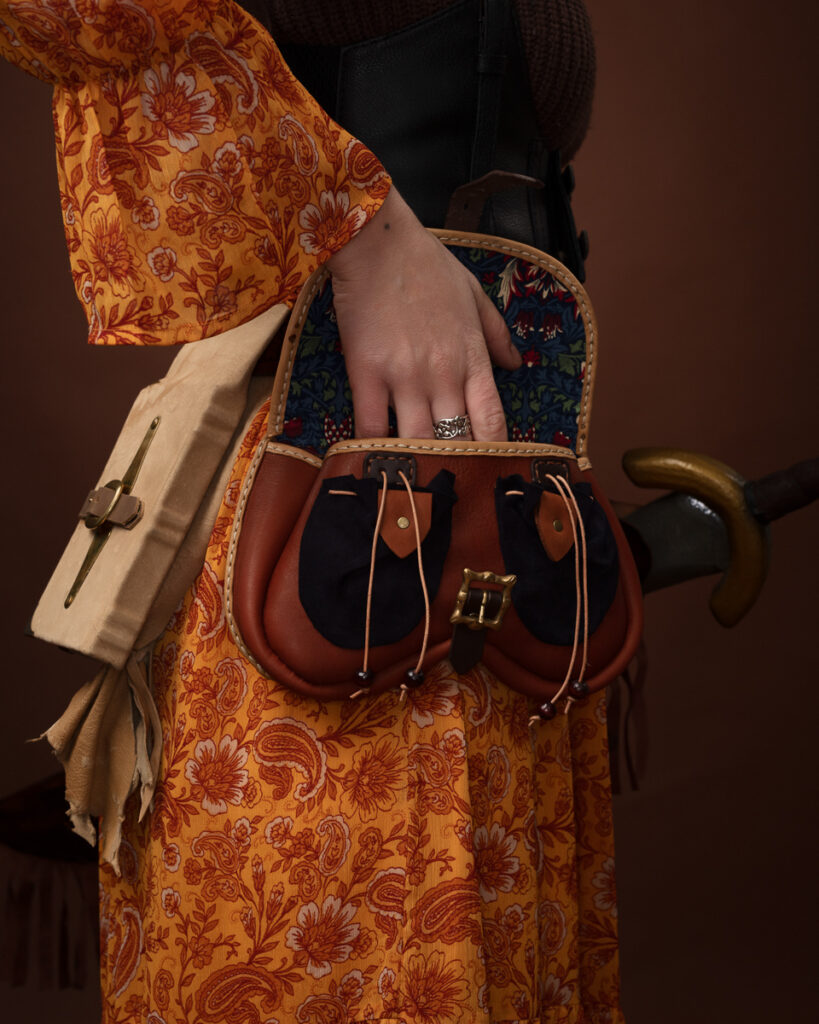 Woman's hand in a medieval style leather pouch