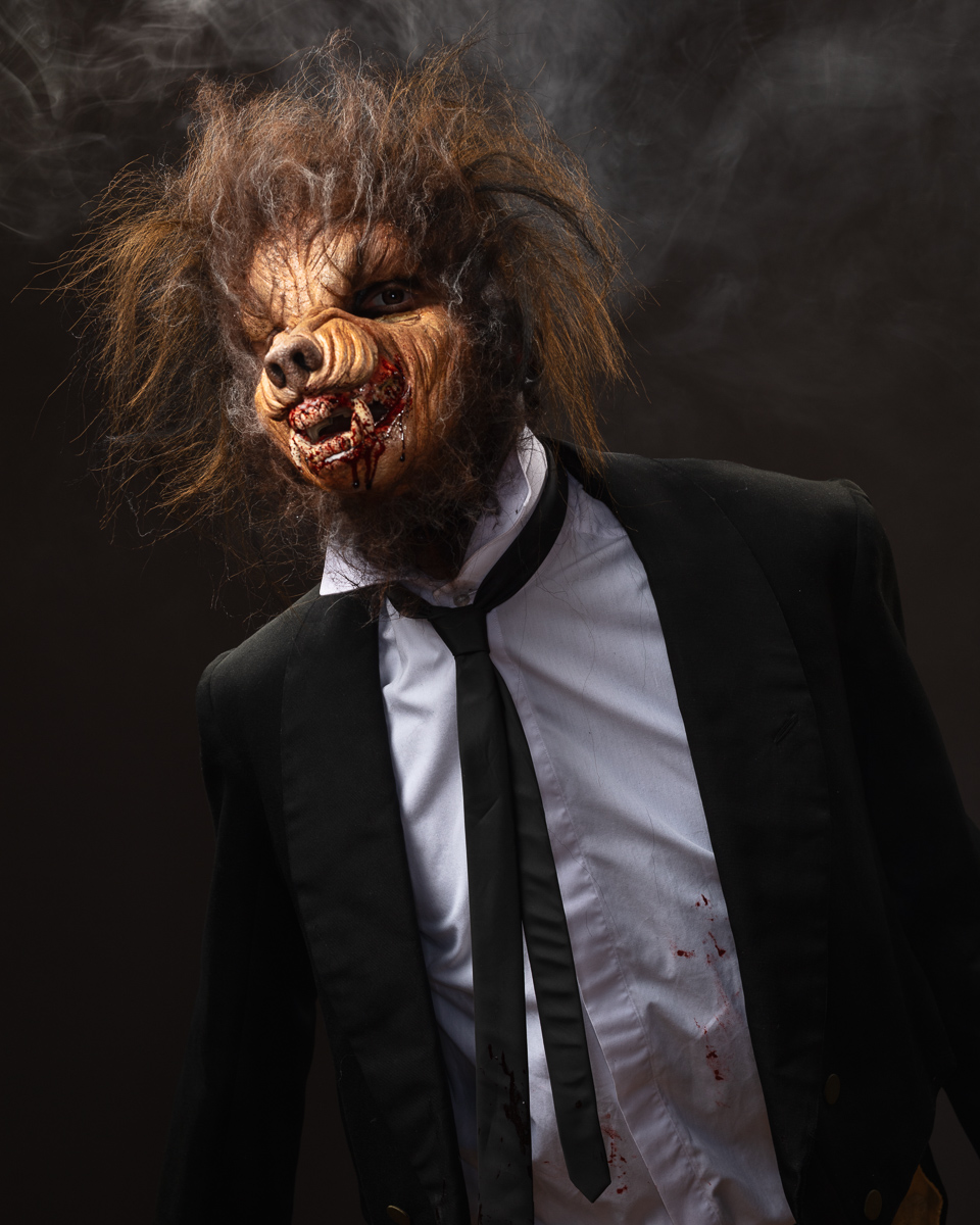 Werewolf in suit with blood, smoky background.