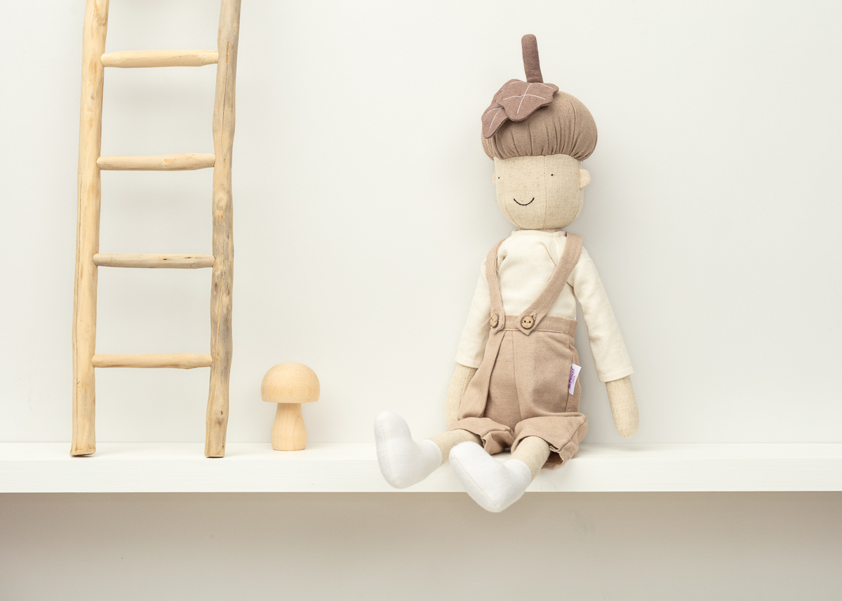 Handmade doll on shelf with wooden ladder decoration.