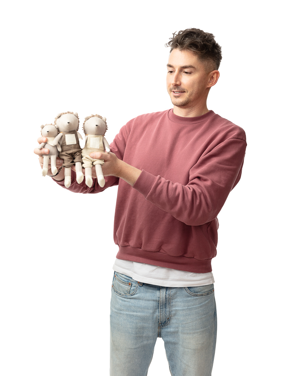 Man holding three stuffed toys.