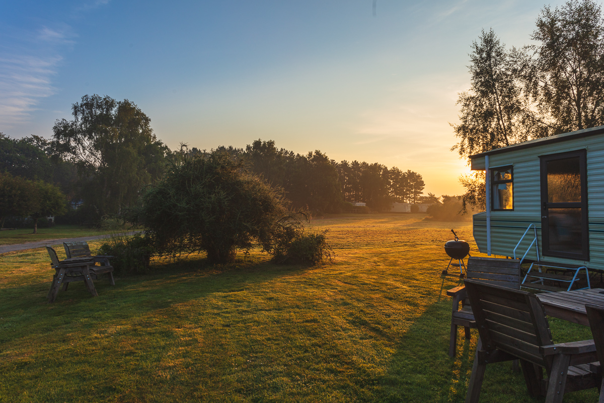 Peaceful dawn at countryside caravan park landscape.