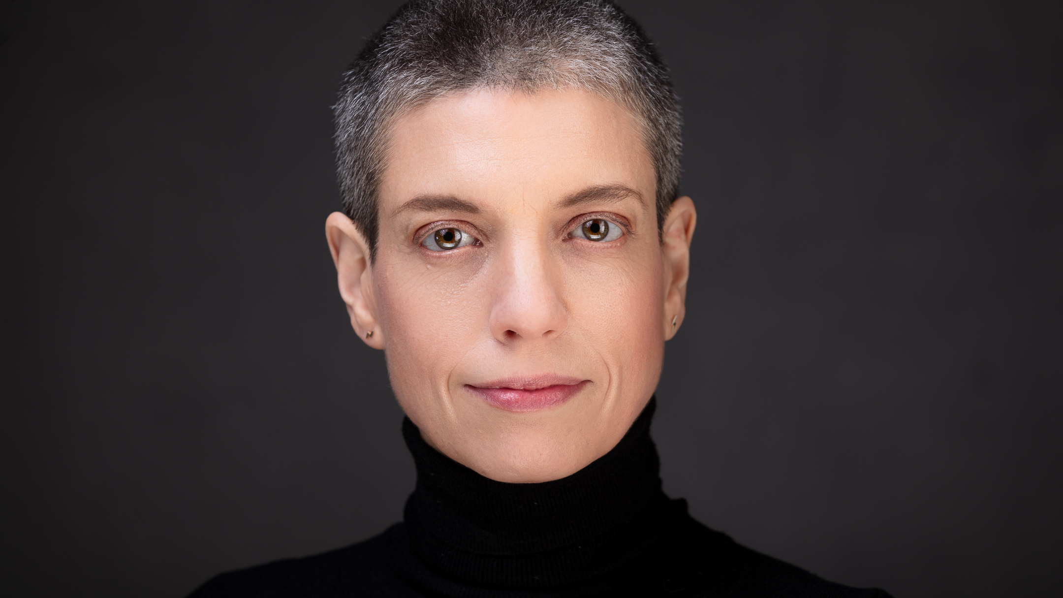 Person with short hair wearing black turtleneck