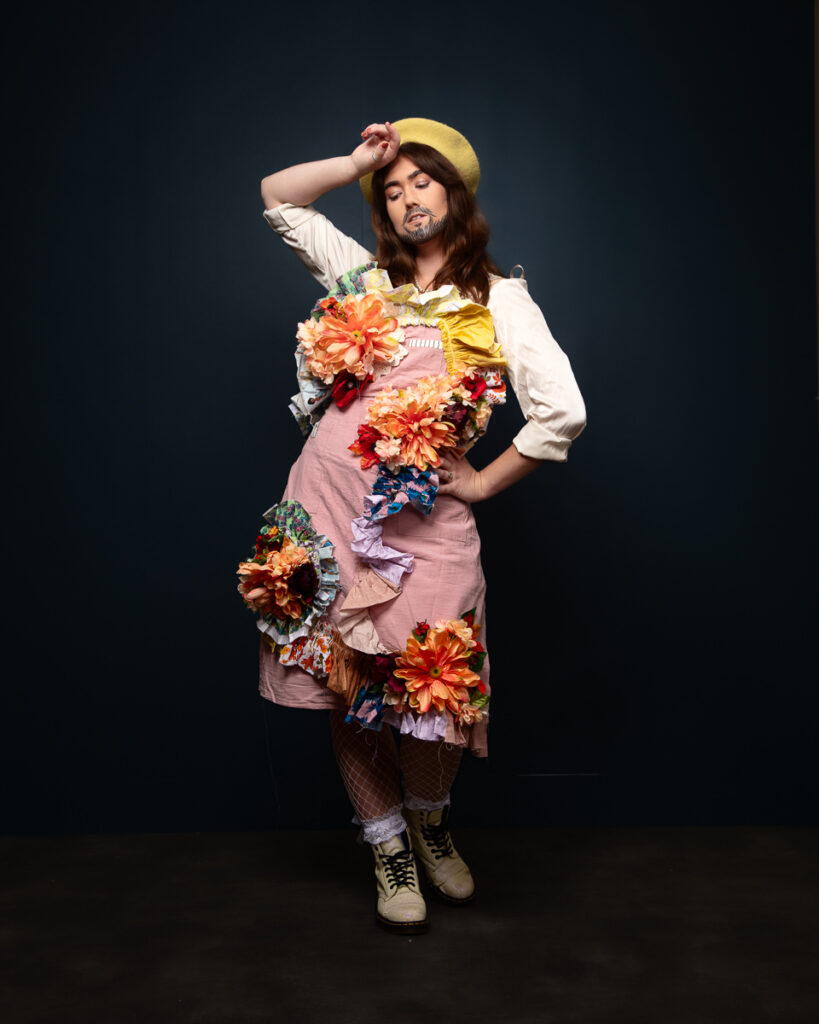 Person in creative, floral fashion with beret posing confidently.
