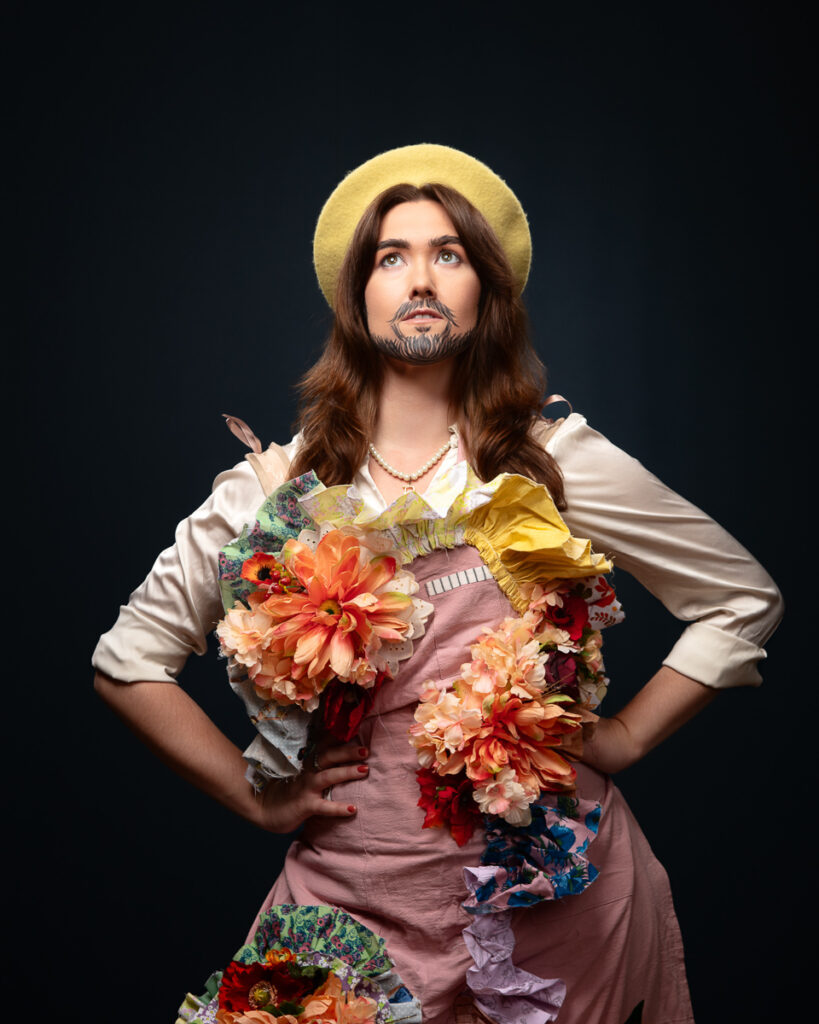 Person adorned with colourful flowers and a beard painting.