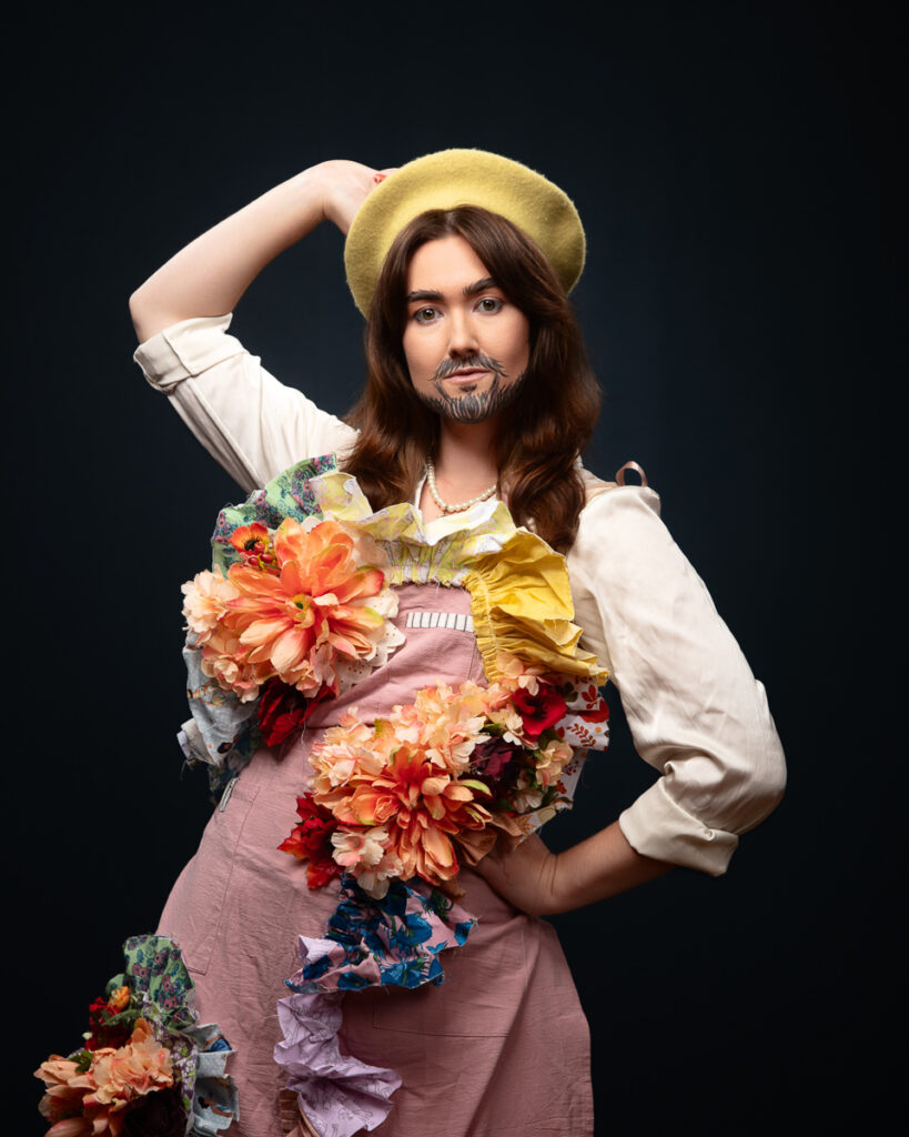 Person in colourful flowered outfit and beret poses confidently.