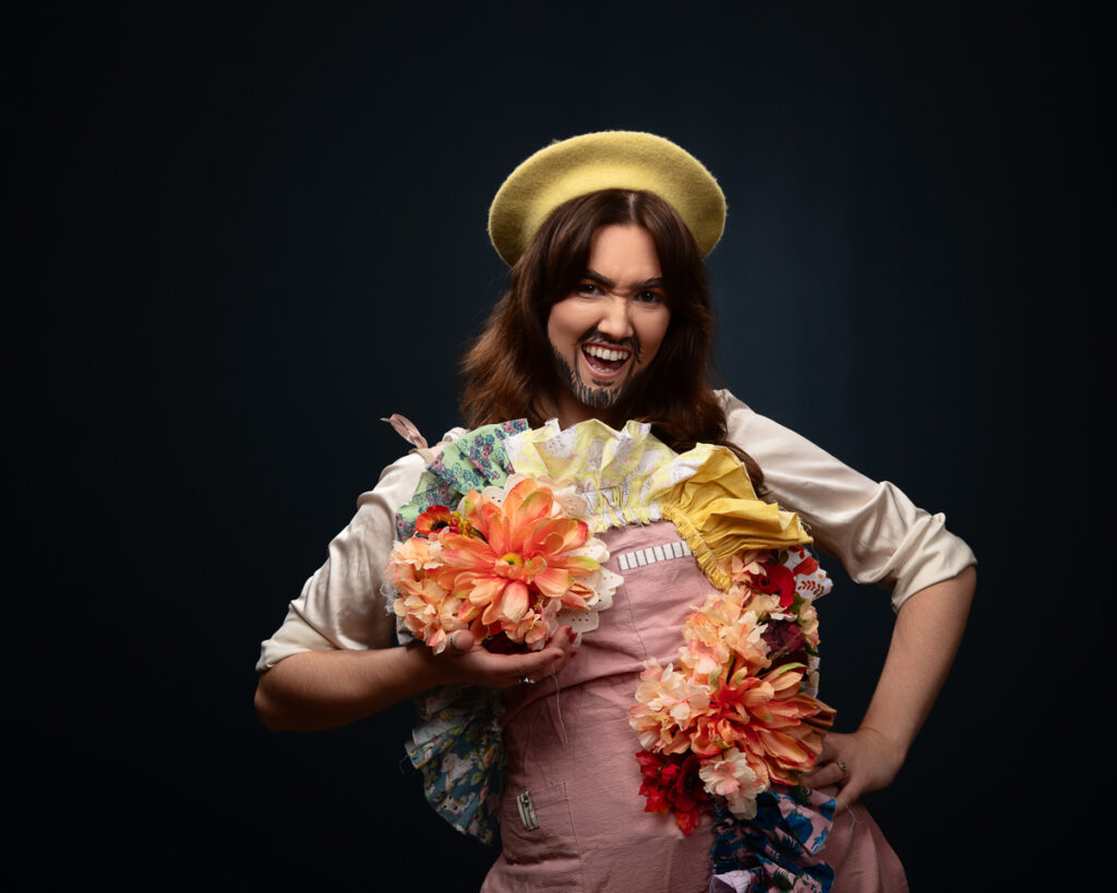 Person in costume with flowers and yellow hat.