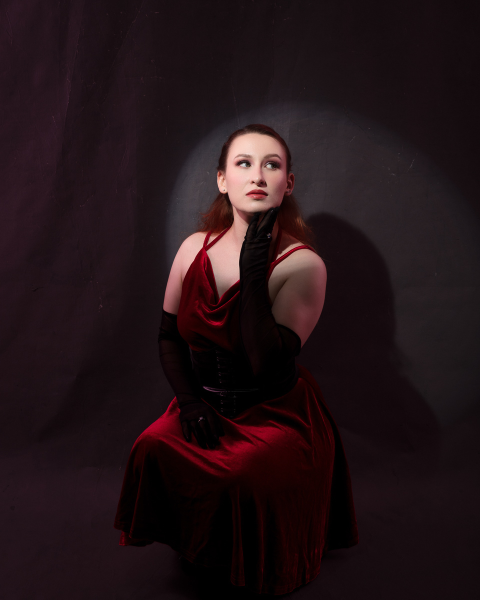 Woman in red dress posing thoughtfully
