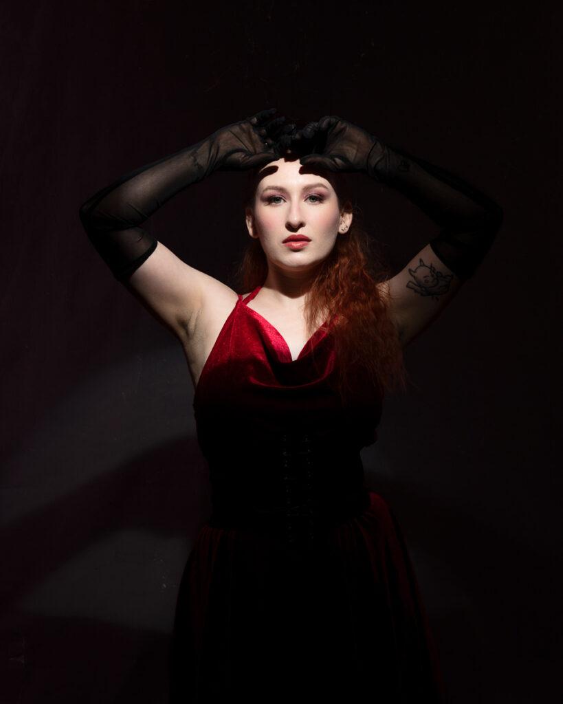 Woman in black gloves and red velvet dress.
