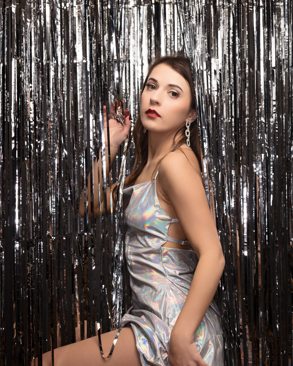Woman in silver dress with metallic streamers.
