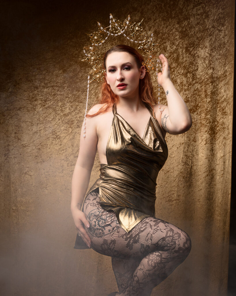 Woman in gold dress with floral headdress.