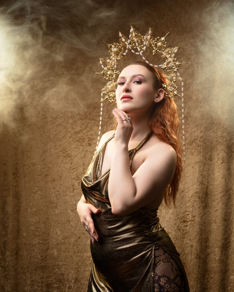 Woman in golden dress with ornate headpiece.