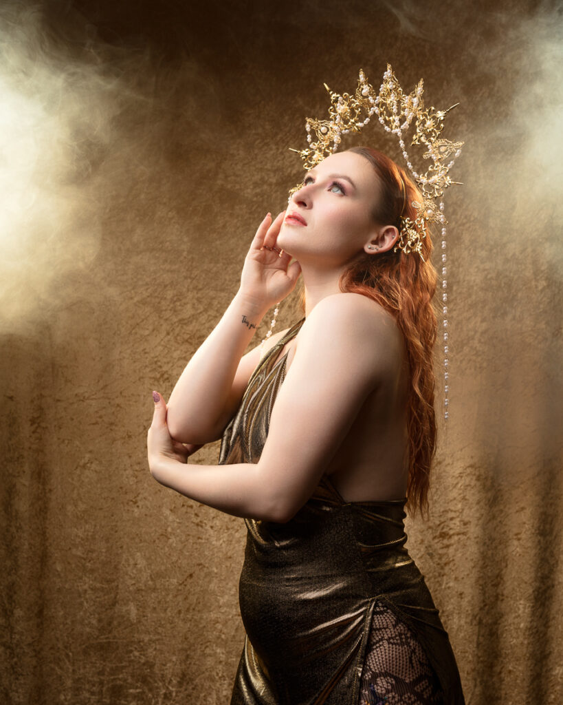 Woman in golden dress and crown with light background