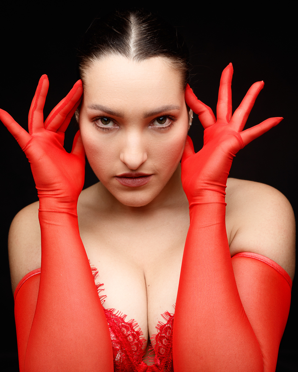 Woman in red gloves with intense gaze.