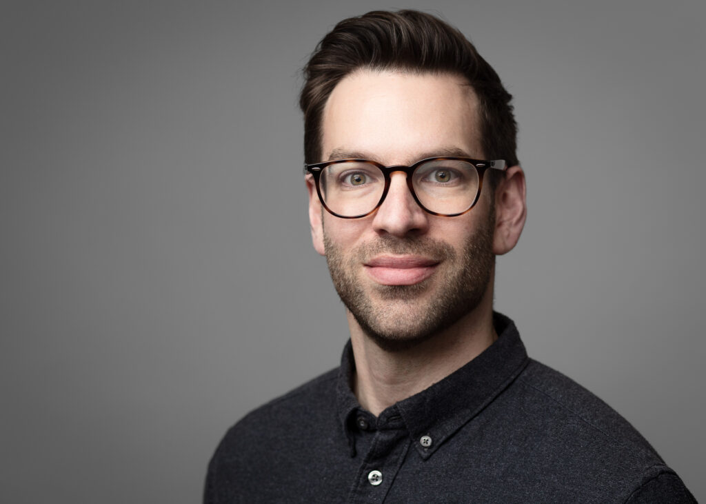 Man with glasses and beard smiling