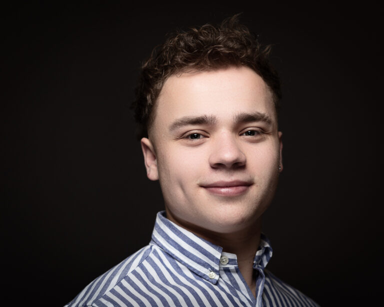 Smiling person in striped shirt.