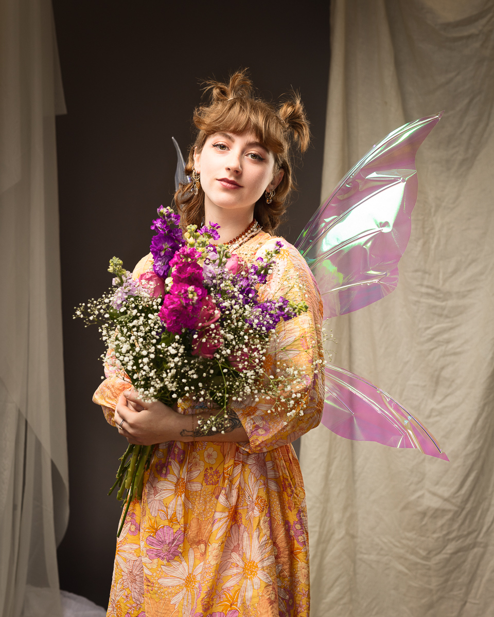 Woman in fairy costume holding colourful flowers