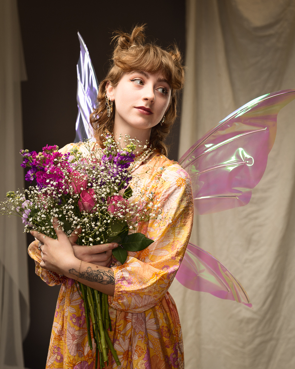 Woman in costume holding bouquet of flowers.