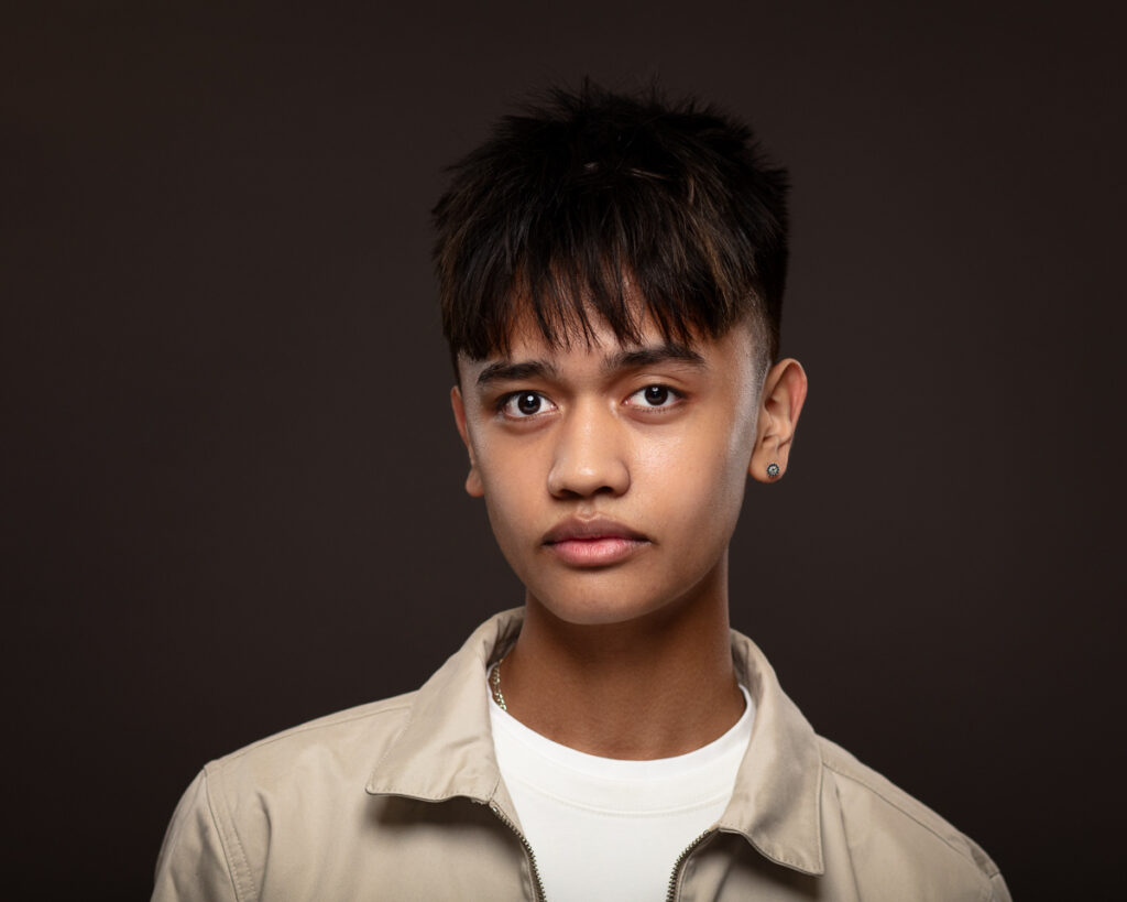 Portrait of a young man with earrings.