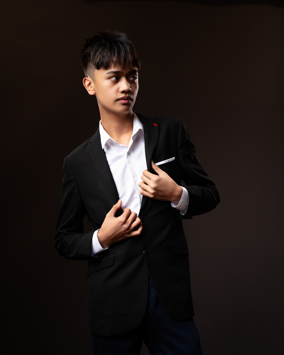 Young man in suit posing confidently.