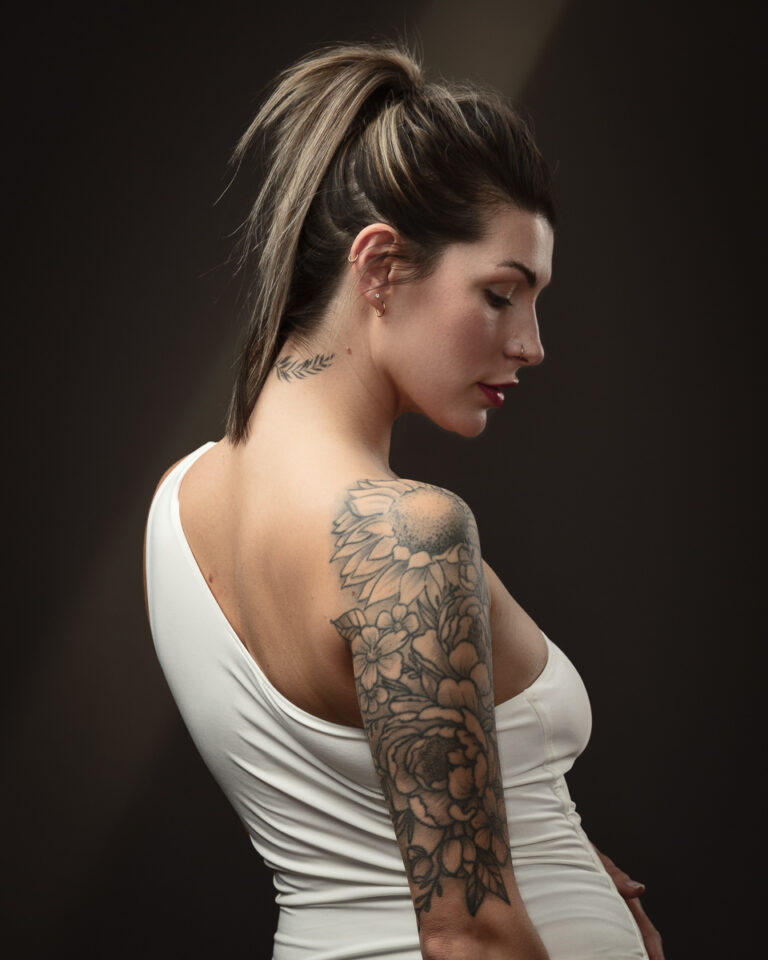 Woman with floral tattoo on arm, elegant pose