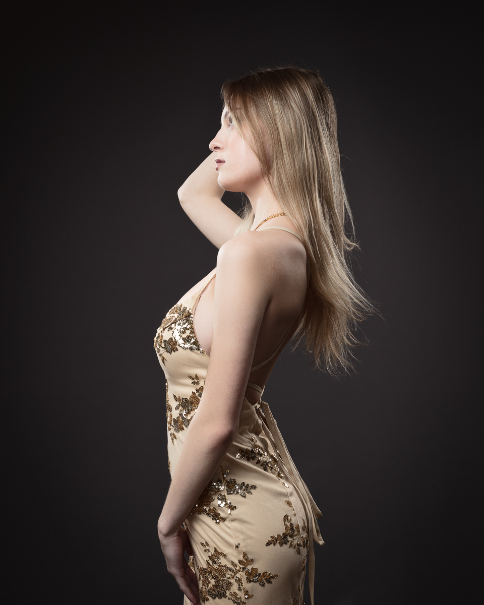Woman in golden dress posing stylishly