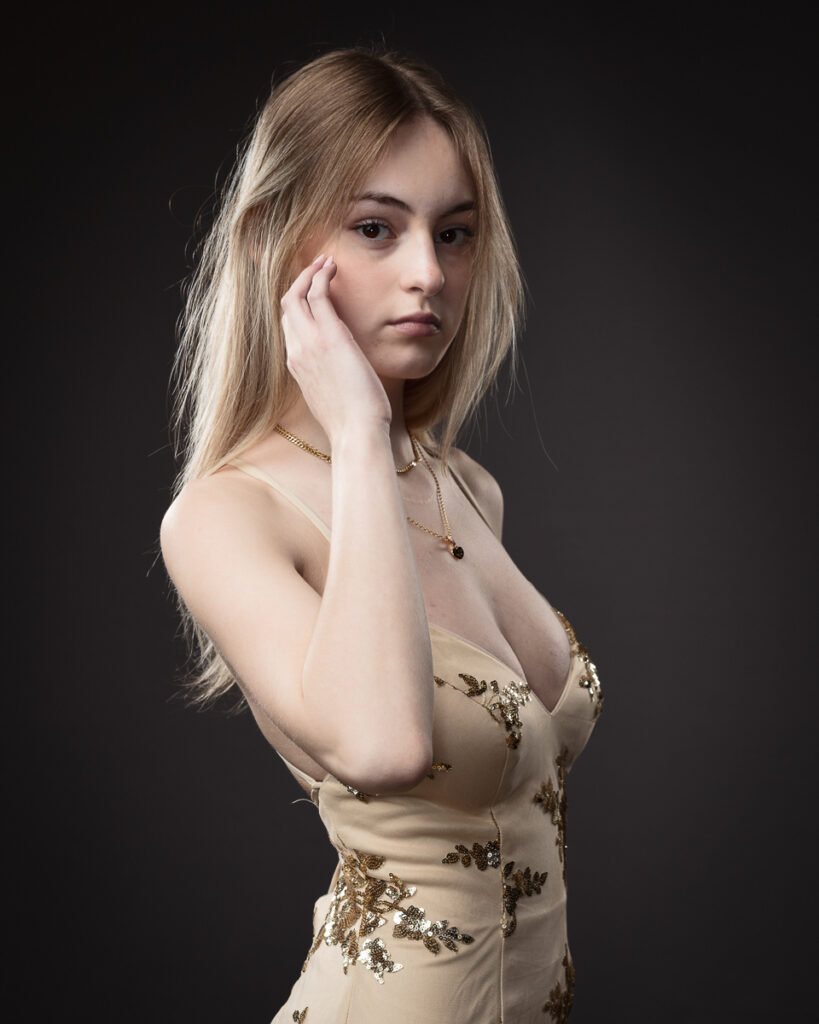 Woman in elegant dress posing confidently.