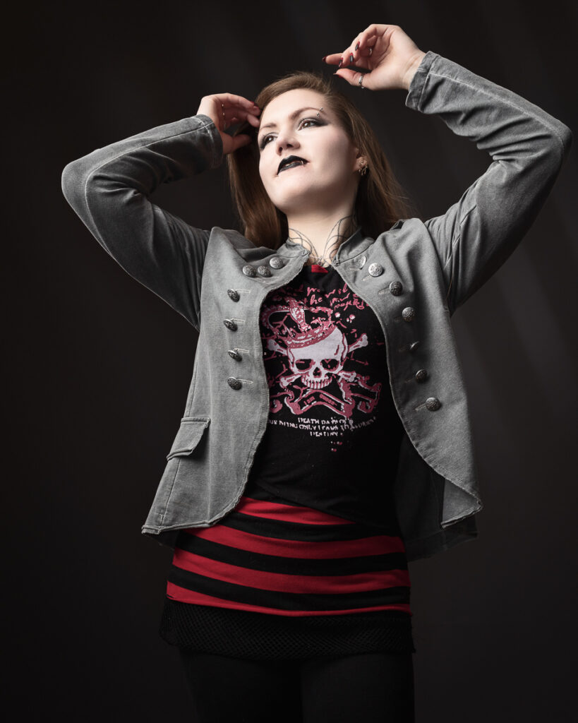 Woman in grey jacket with skull print shirt.
