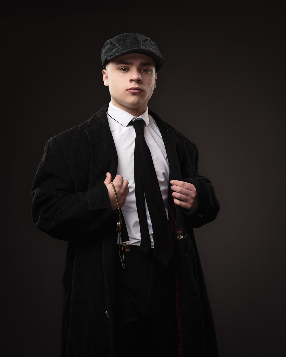 Man in vintage attire with cap and coat.