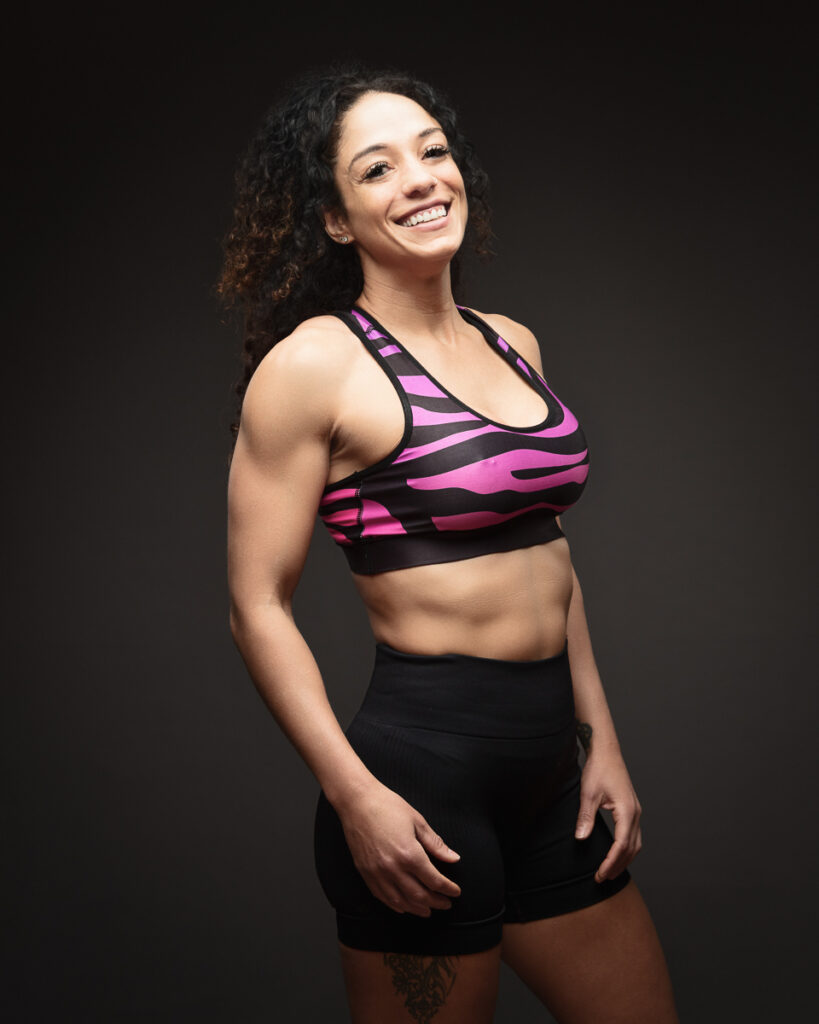 Smiling woman in sports attire on dark background