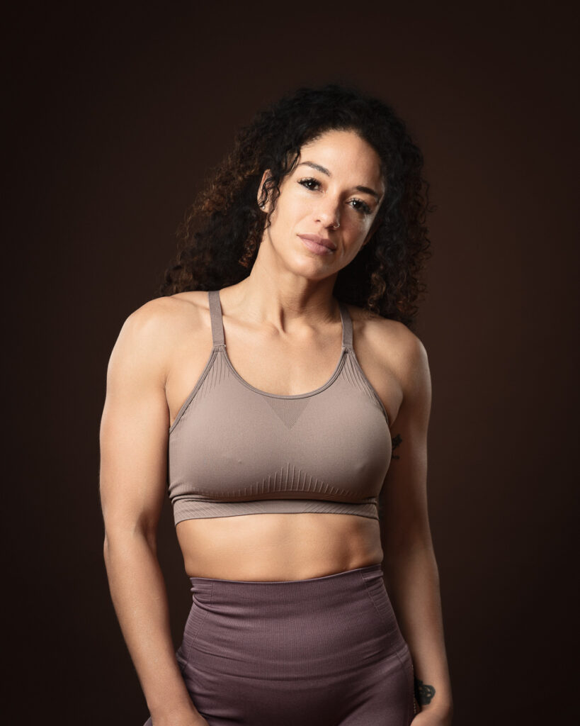 Woman in athletic wear against dark background