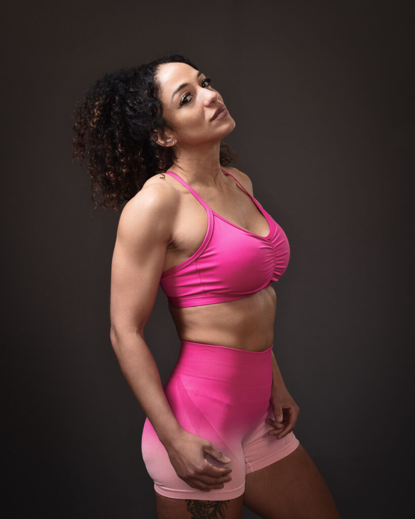 Woman in pink activewear posing in studio