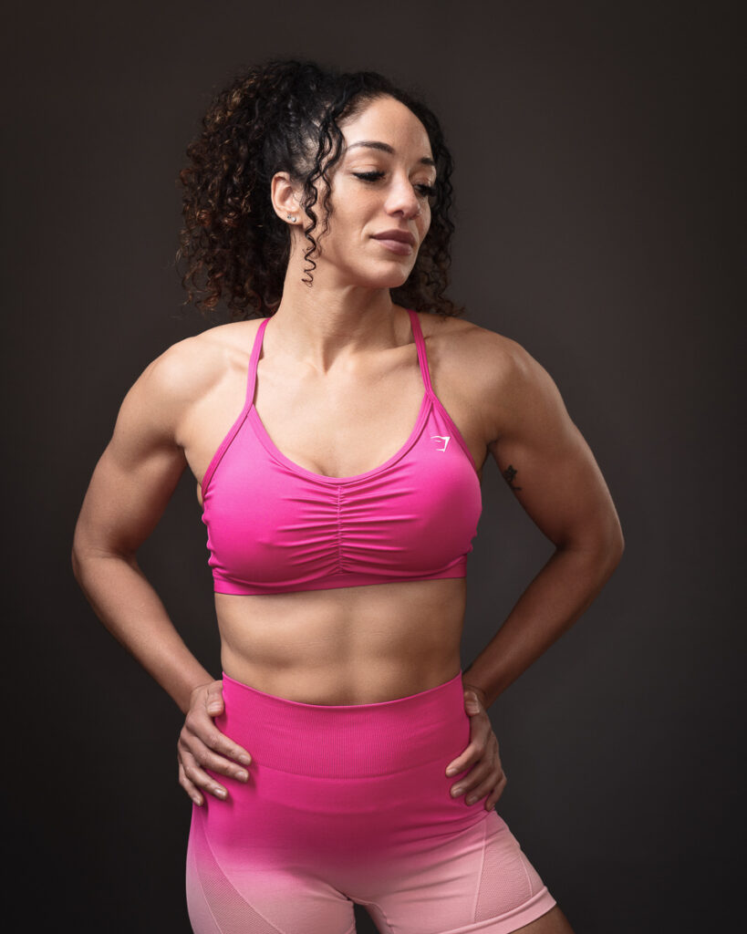 Woman in pink activewear posing confidently.