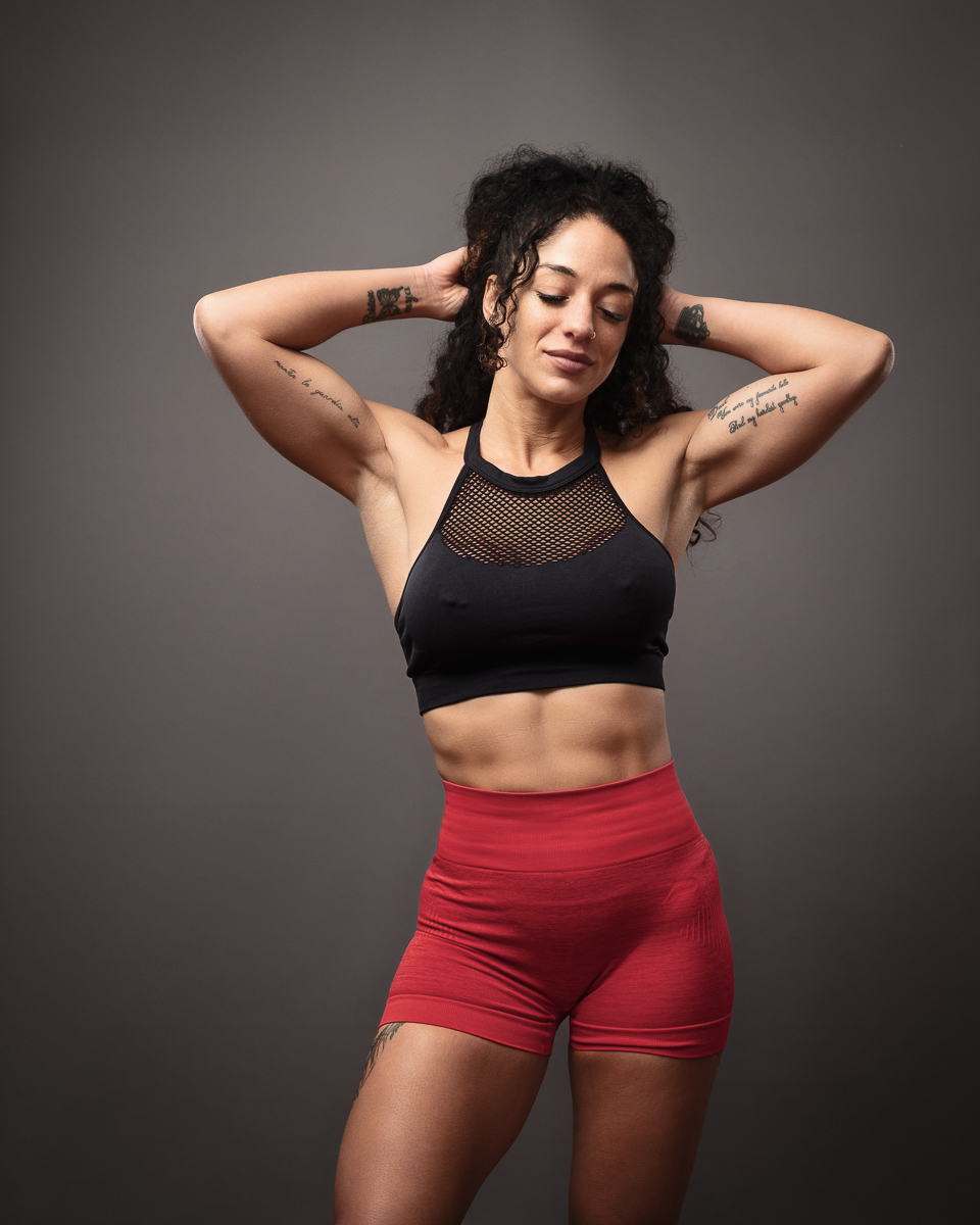 Woman posing in fitness outfit with tattoos